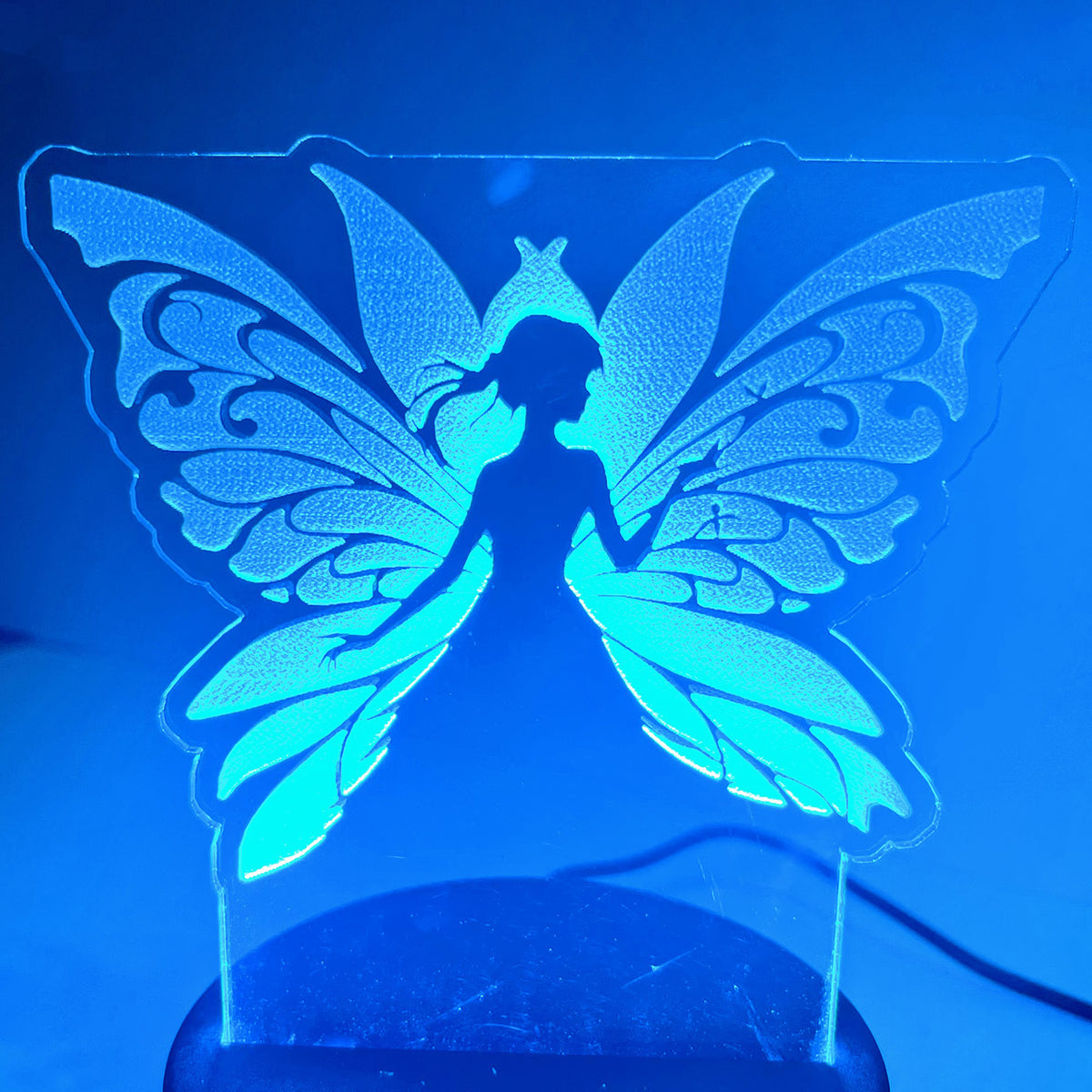 Fairy LED Nightlight #6 glowing in blue with delicate wing design.