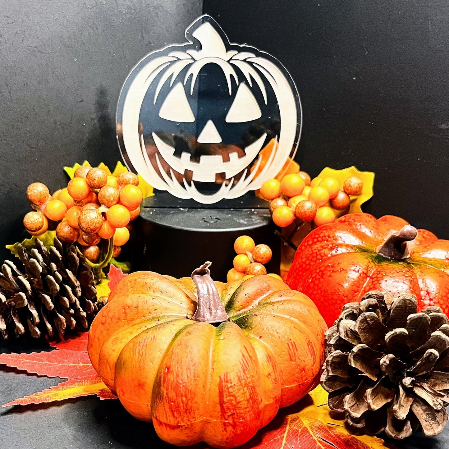 Smiling Jack-O-Lantern LED nightlight with autumn decorations.